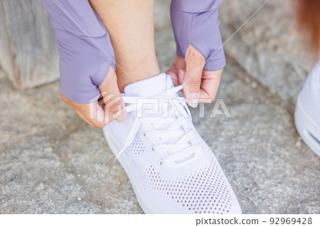 在運動鞋上系鞋帶 92969428