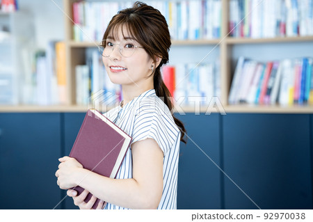 Young woman in glasses with a book 92970038
