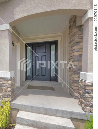Vertical Whispy white clouds Facade of a front exterior of a house with front yard garden 92970148
