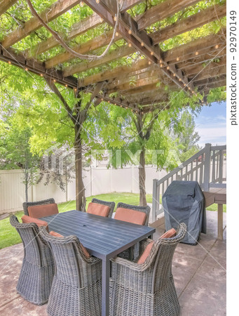 Vertical Outdoor patio with covered barbecue grill under a pergola roof with vines Vertical Outdoor patio with covered barbecue grill under a pergola roof with vines 92970149