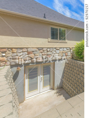 Vertical Whispy white clouds Basement entrance with glass panels on the double doors Vertical Whispy white clouds Basement entrance with glass panels on the double doors 92970157