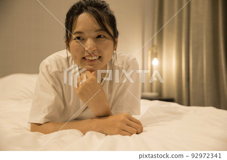 晚上在臥室裡放鬆的年輕女人 92972341