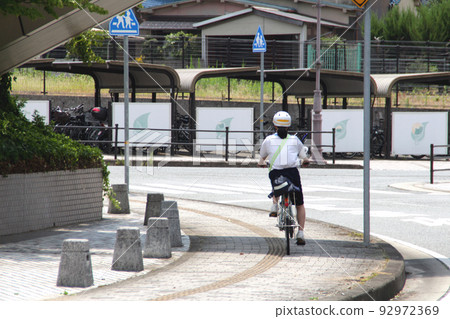 Rural high school girl commuting to school by bicycle 92972369