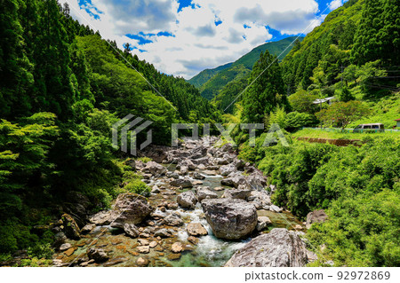 The clear stream that flows through the mountains and the private houses scattered about 92972869
