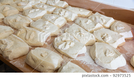 Portioned pieces of dough prepared for shaping in bakery 92973525