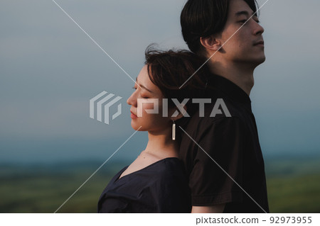 man and woman back to back in nature 92973955