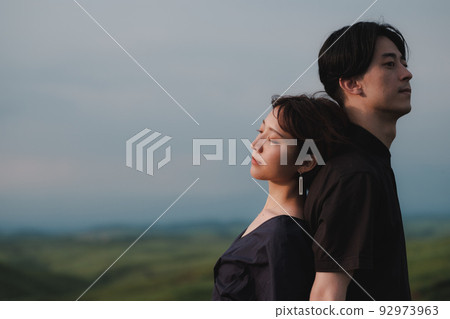 man and woman back to back in nature 92973963