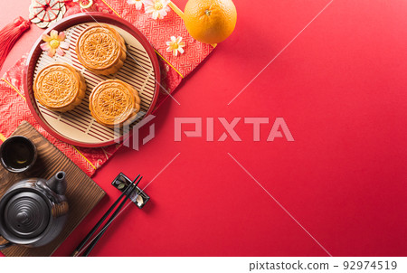 Chinese Mid-Autumn Festival concept made from mooncakes, tea and plum blossom. Chinese characters FU in the article refer to fortune good luck, wealth, money flow. 92974519