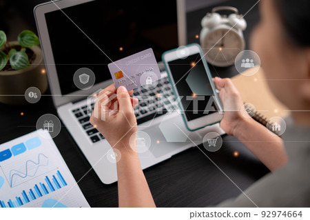 Close up shot of females hands holding credit card tand smart phone with technology icons. 92974664