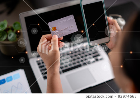 Close up shot of females hands holding credit card tand smart phone with technology icons. 92974665