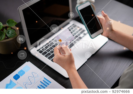 Close up shot of females hands holding credit card tand smart phone with technology icons. 92974666