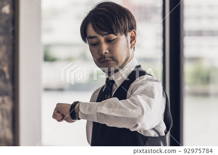 Businessman confirming time 92975784