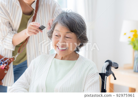 Senior woman having her hair taken care of by a hairdresser 92975961