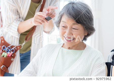 Senior woman having her hair taken care of by a hairdresser 92975962