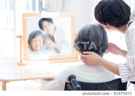 Senior woman having her hair taken care of by a hairdresser 92975971