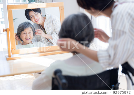 Senior woman having her hair taken care of by a hairdresser 92975972