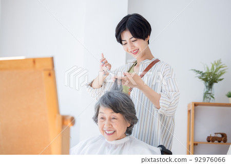 Senior woman having her hair taken care of by a hairdresser Senior woman having her hair taken care of by a hairdresser 92976066