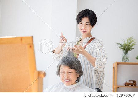 Senior woman having her hair taken care of by a hairdresser Senior woman having her hair taken care of by a hairdresser 92976067