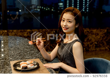 Woman eating sushi Woman eating sushi 92976338