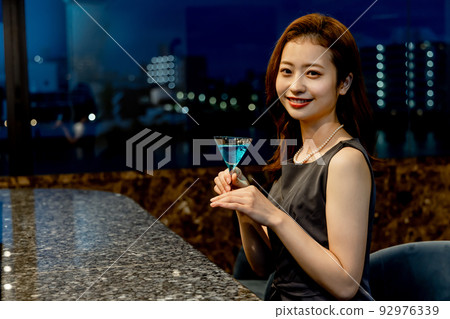 A woman drinking cocktail A woman drinking cocktail 92976339
