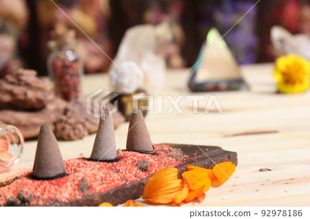 Incense Cones on Stone Slab With Crystals and Flowers 92978186