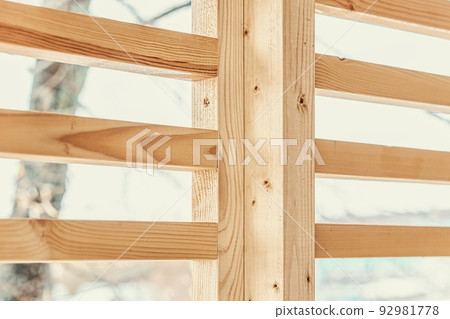 Stylish decorative partition wall made of thin wooden planks stands on contemporary country house terrace on winter day closeup 92981778