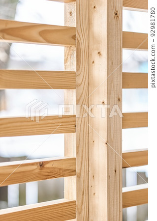 Stylish decorative partition wall made of thin wooden planks stands on contemporary country house terrace on winter day closeup Stylish decorative partition wall made of thin wooden planks stands on contemporary country house terrace on winter day closeup 92981780