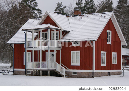 Typical scandinavian red wooden house in village 92982024