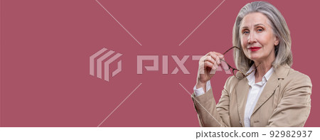 Woman holding eyeglasses and having a thoiughful look Woman holding eyeglasses and having a thoiughful look 92982937