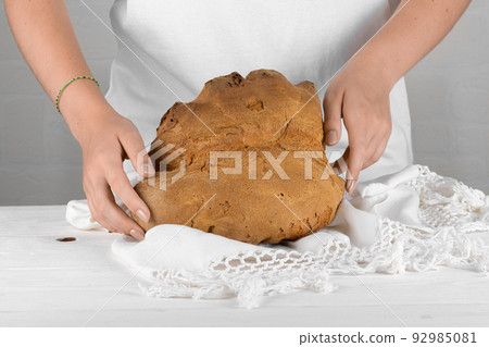 Female hands putting the bread of Matera, Pane di Matera on white background, typical southen italian sourdough bread 92985081