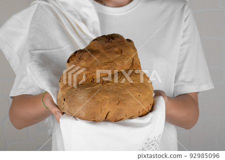 Female hands holding the bread of Matera, Pane di Matera on white background, typical southen italian sourdough bread Female hands holding the bread of Matera, Pane di Matera on white background, typical southen italian sourdough bread 92985096