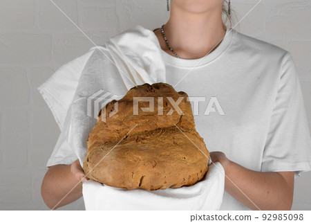 young woman holding the bread of Matera, Pane di Matera on white background, typical southen italian sourdough bread young woman holding the bread of Matera, Pane di Matera on white background, typical southen italian sourdough bread 92985098