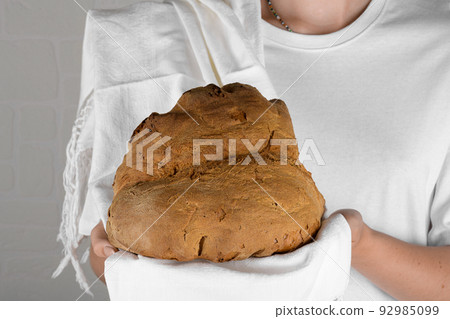 Female hands holding the bread of Matera, Pane di Matera on white background, typical southen italian sourdough bread Female hands holding the bread of Matera, Pane di Matera on white background, typical southen italian sourdough bread 92985099