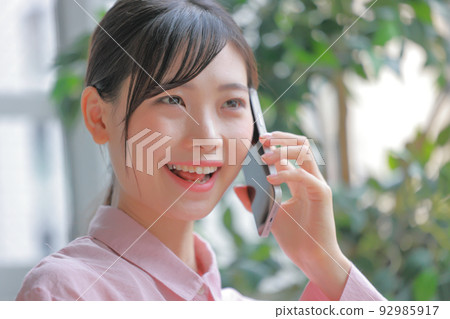 Woman smiling and calling _ closeup 1 92985917