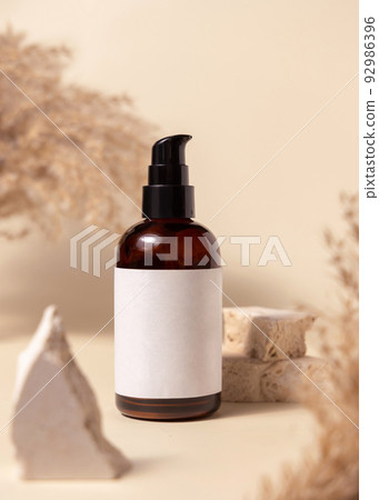 Brown cosmetic bottle with blank label near stones and pampas grass close up, Mockup Brown cosmetic bottle with blank label near stones and pampas grass close up, Mockup 92986396