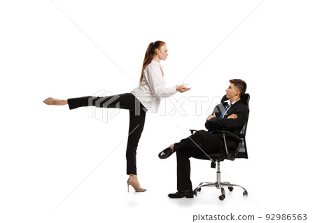 Gender stereotypes. Two stylish office workers in business suits in action isolated on white background. Art, beauty, fashion and business concept 92986563