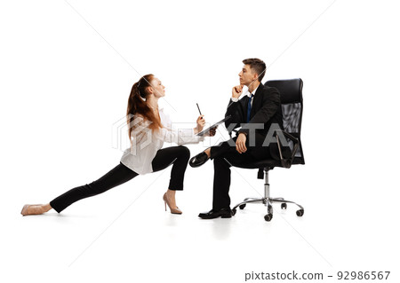 Co-workers. Two stylish office workers in business suits in action isolated on white background. Art, beauty, fashion and business concept 92986567