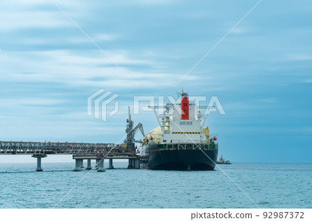 liquefied natural gas carrier tanker during loading at an LNG offshore terminal, in the distance the oil export terminal is visible in the sea 92987372