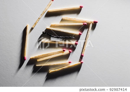 Single match protruding from matchbox.Close-up shot. Single match protruding from matchbox.Close-up shot. 92987414