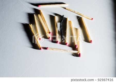 Single match protruding from matchbox.Close-up shot. Single match protruding from matchbox.Close-up shot. 92987416