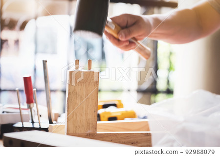 Focus on the woodwork, Entrepreneur Woodwork holding hammer to assemble the wood pieces as the customer ordered. Focus on the woodwork, Entrepreneur Woodwork holding hammer to assemble the wood pieces as the customer ordered. 92988079