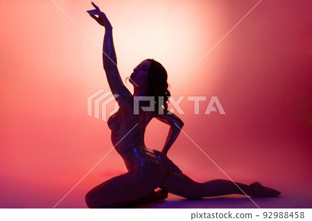 Alluring naked lady with perfect body sitting in studio with raised arm 92988458