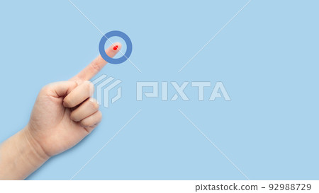 World diabetes day awareness concept. Finger with blood drop and blue circle of universal symbol for diabetes. Support for the fight against diabetes. World diabetes day awareness concept. Finger with blood drop and blue circle of universal symbol for diabetes. Support for the fight against diabetes. 92988729