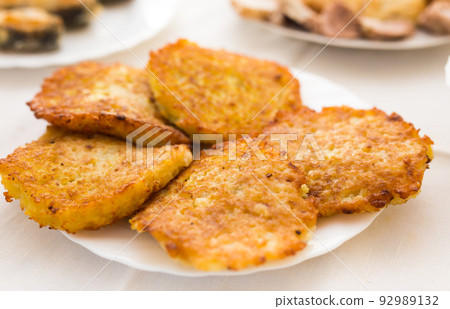 Fried grated potato pancakes with sour cream on white plate 92989132