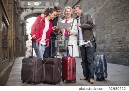 tourists with suitcases and camera walk along the historic streets of European city tourists with suitcases and camera walk along the historic streets of European city 92989212