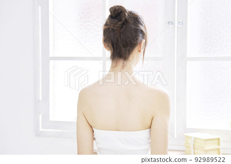 The back of a woman wearing a tube top in the living room The back of a woman wearing a tube top in the living room 92989522