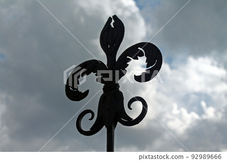 The iron lily on the top of a tower with a dramatic clouded sky 92989666