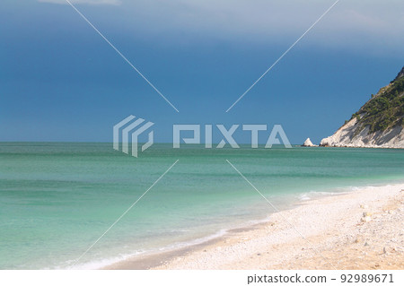 Dramatic sky above the turquoise Adriatic Sea and the white rocks in Portonovo on Conero 92989671