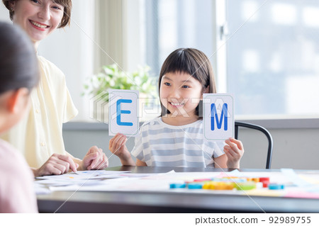 Education A child taking a lesson in an English conversation class and a native teacher Education A child taking a lesson in an English conversation class and a native teacher 92989755