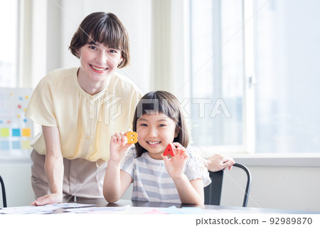 Education A child taking a lesson in an English conversation class and a native teacher 92989870